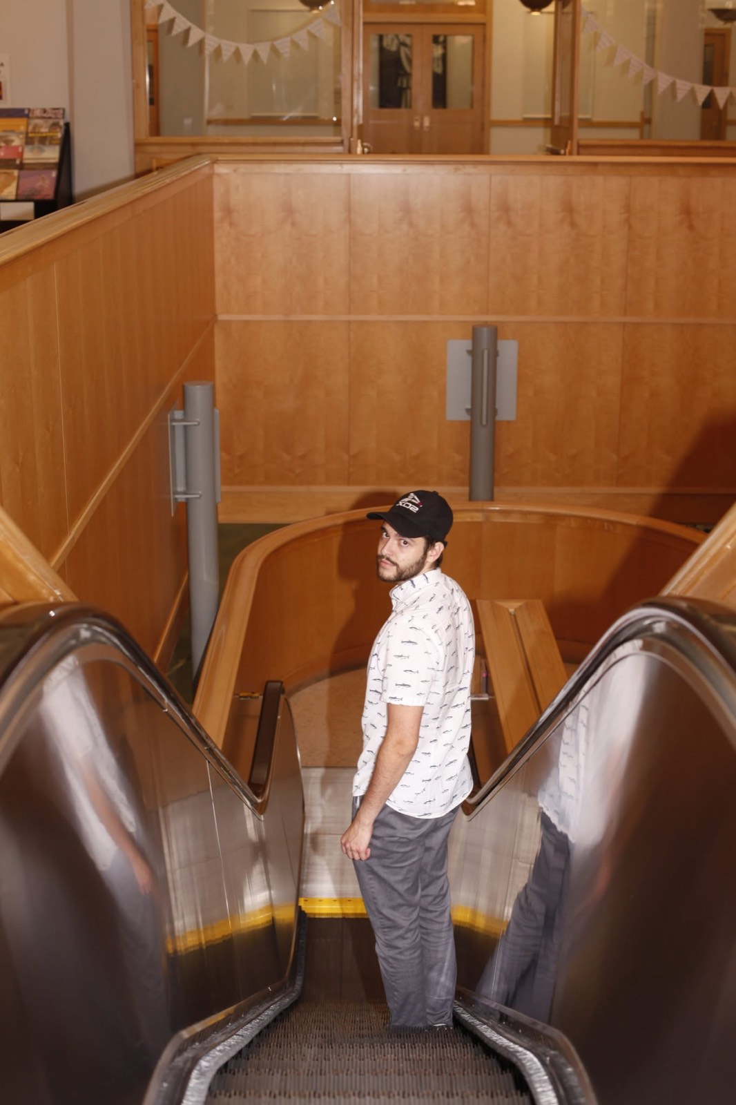 A man on an escalator, looking back over his shoulder